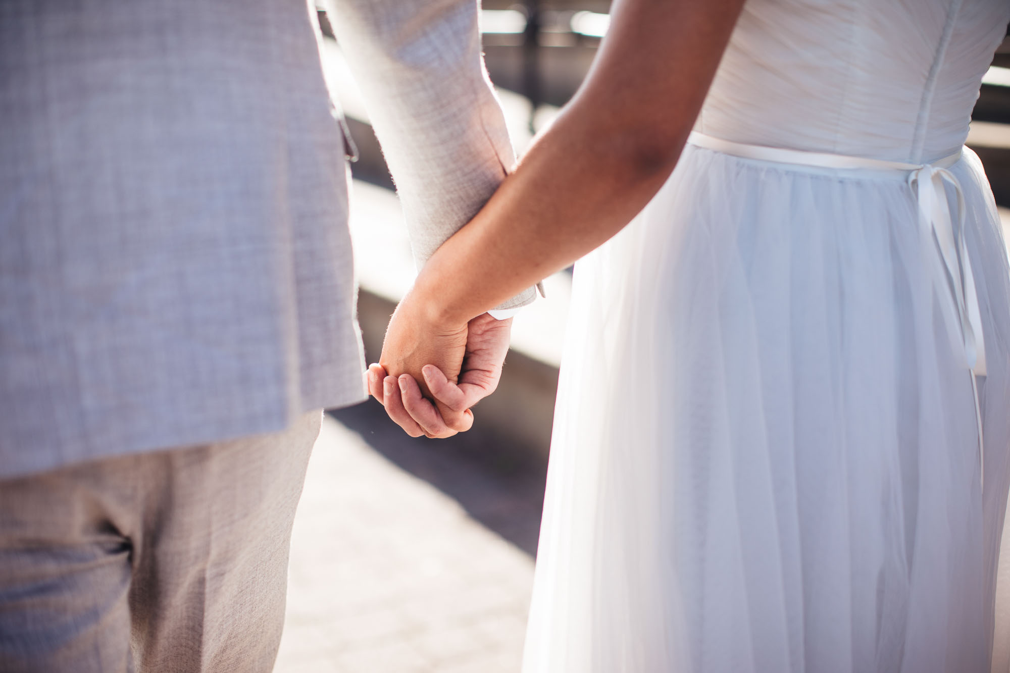 couple holding hands in sunlight