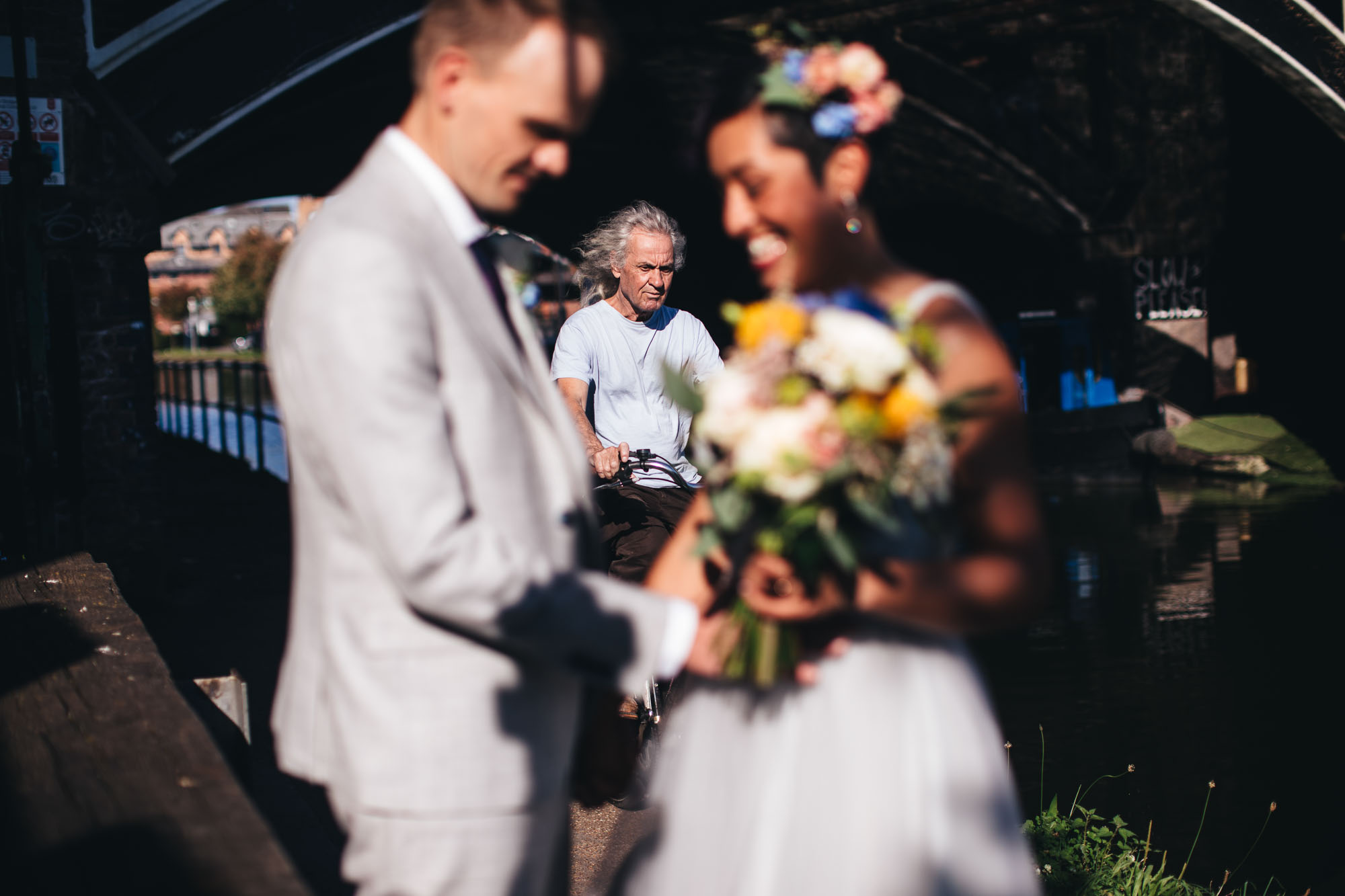 cyclist behind wedding couple