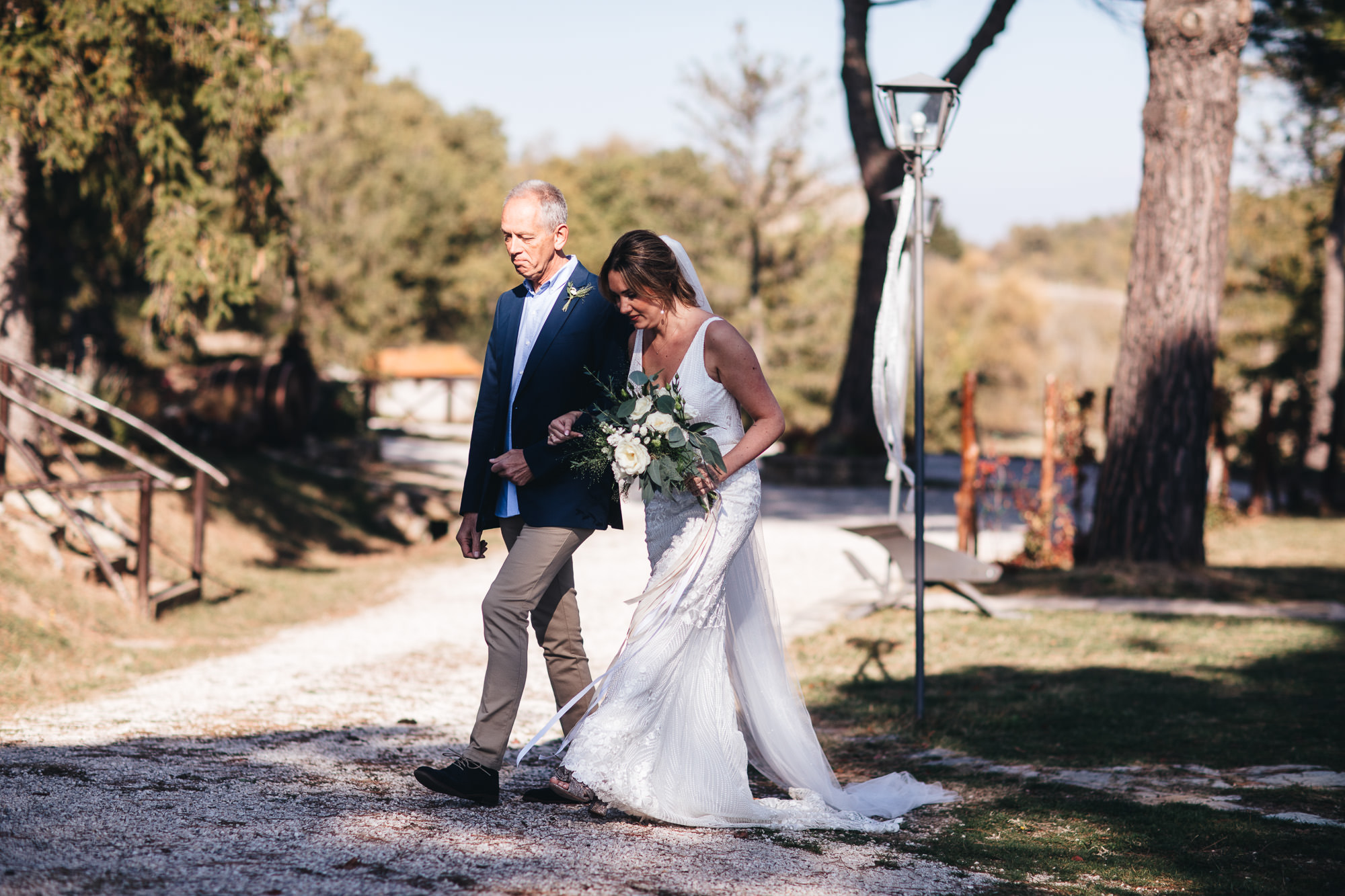 brides walks to ceremony with father