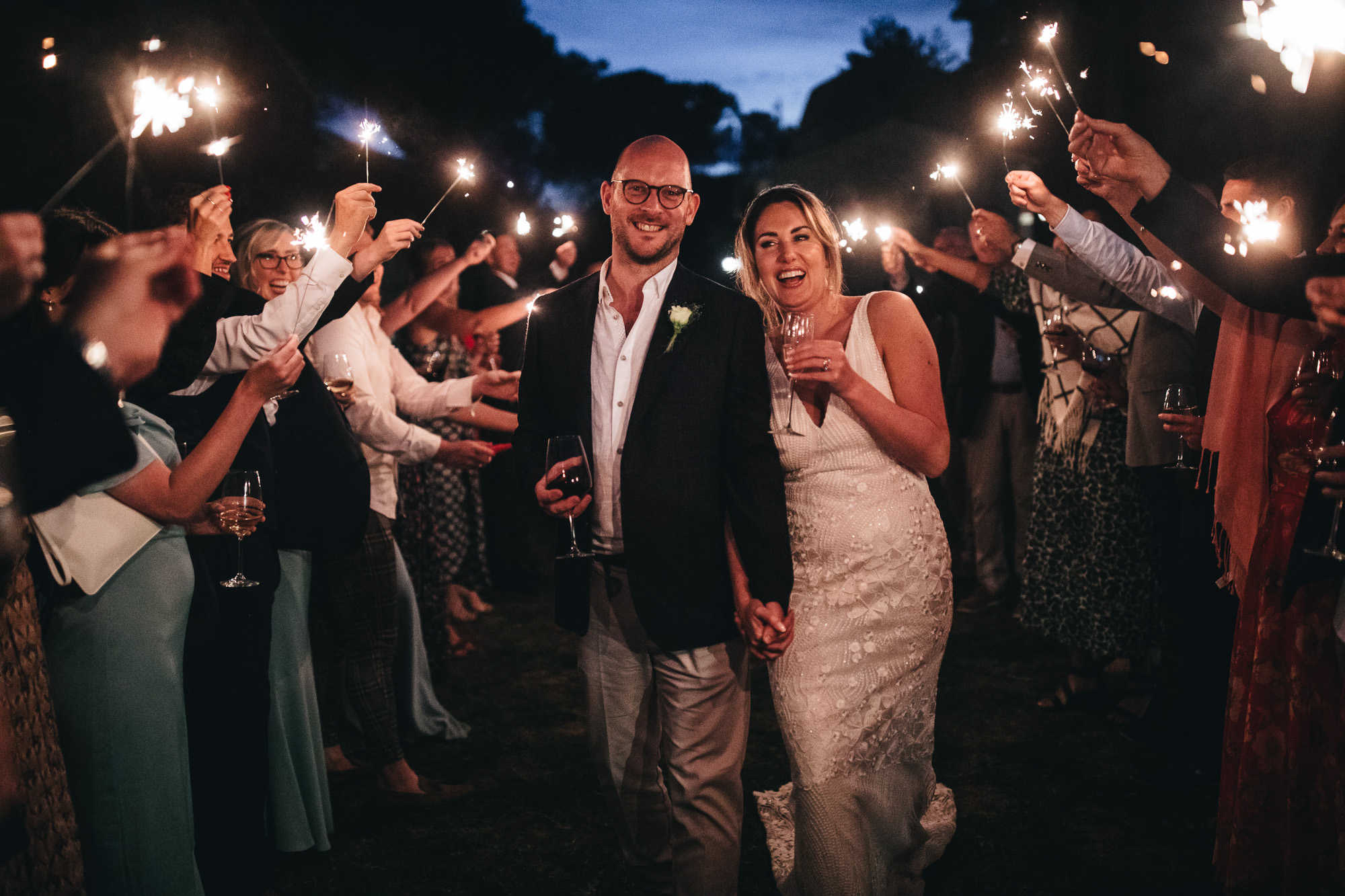 couple walk through tunnel of sparklers