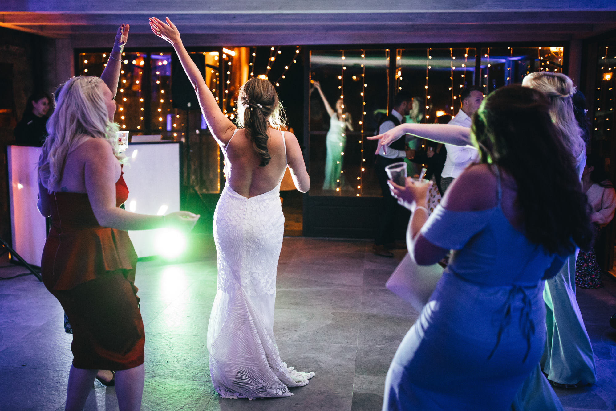 bride from behind hand in the air gesturing to the music