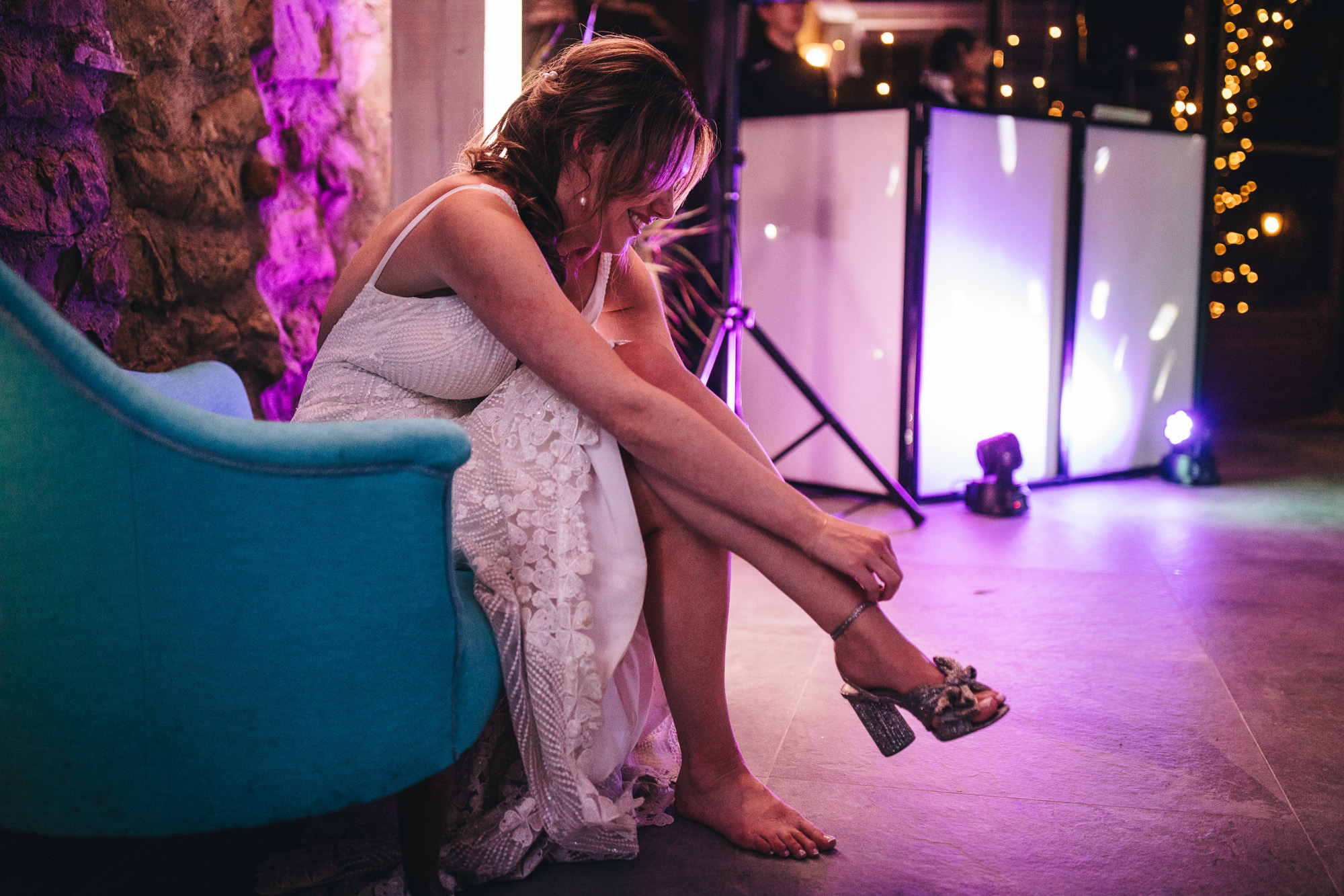 bride taking off her shoes to dance