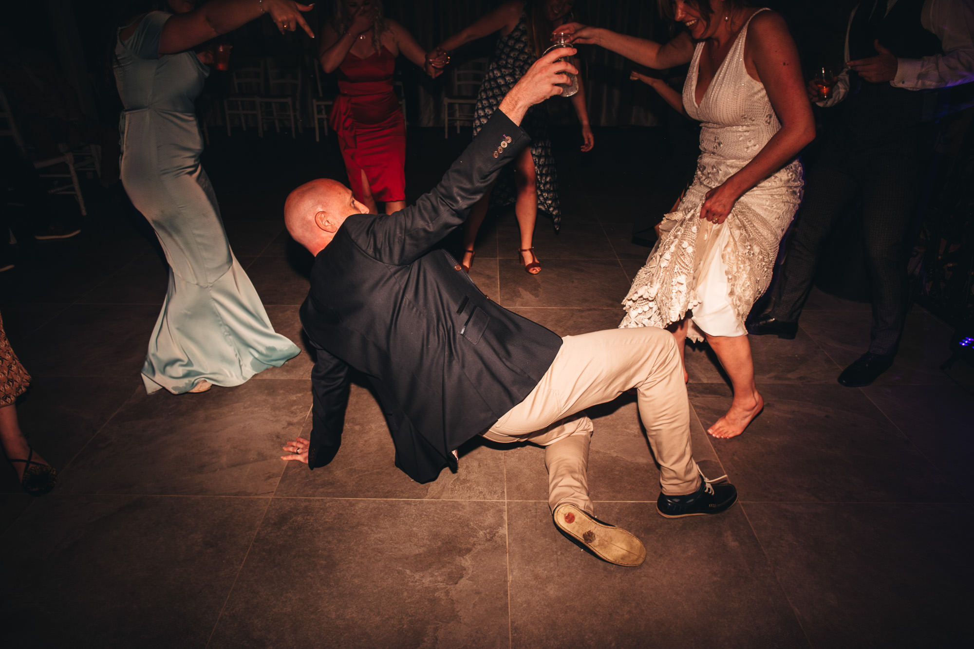 guests break dances on floor with bride