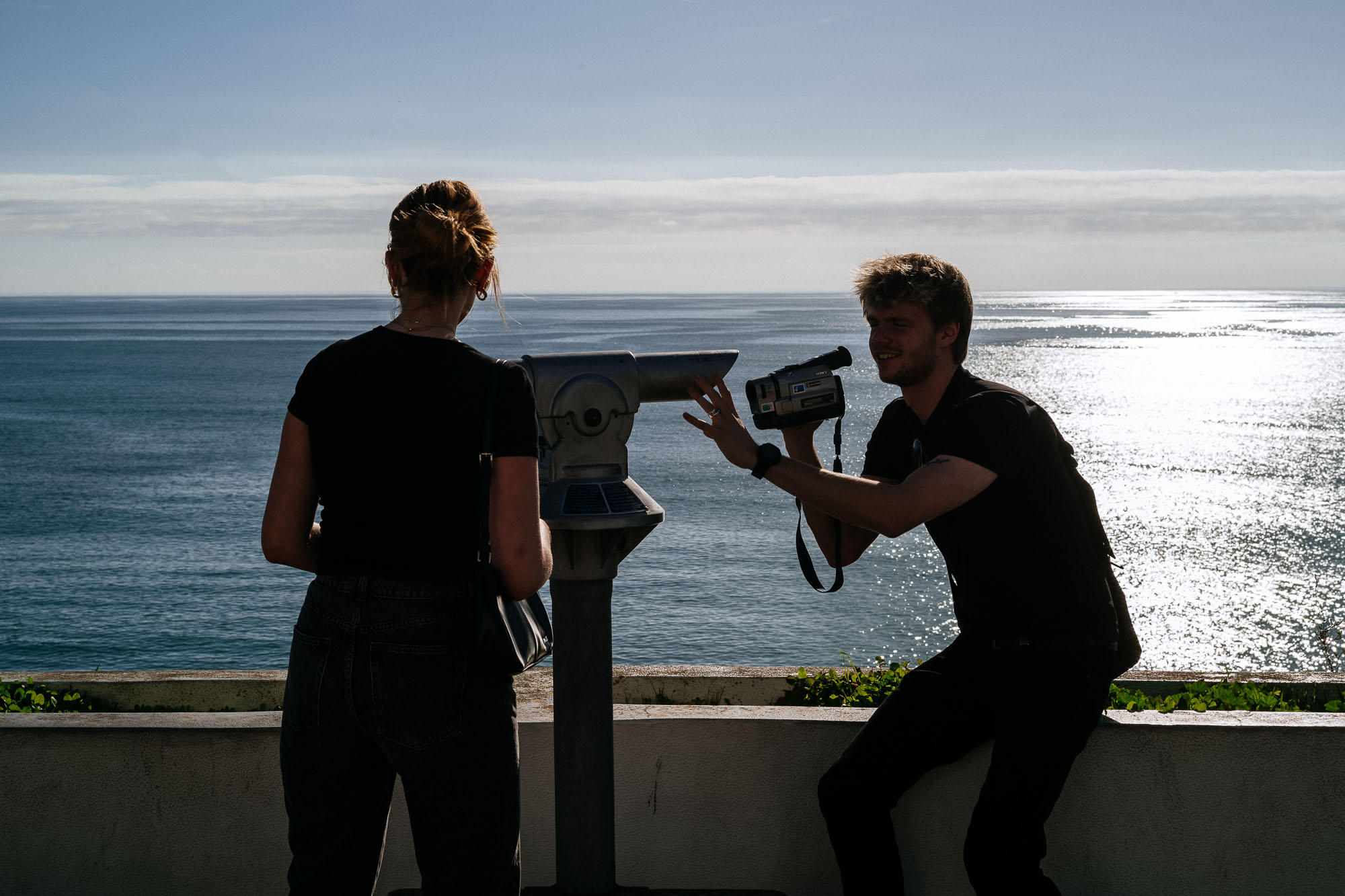 couple filming each other with sea view
