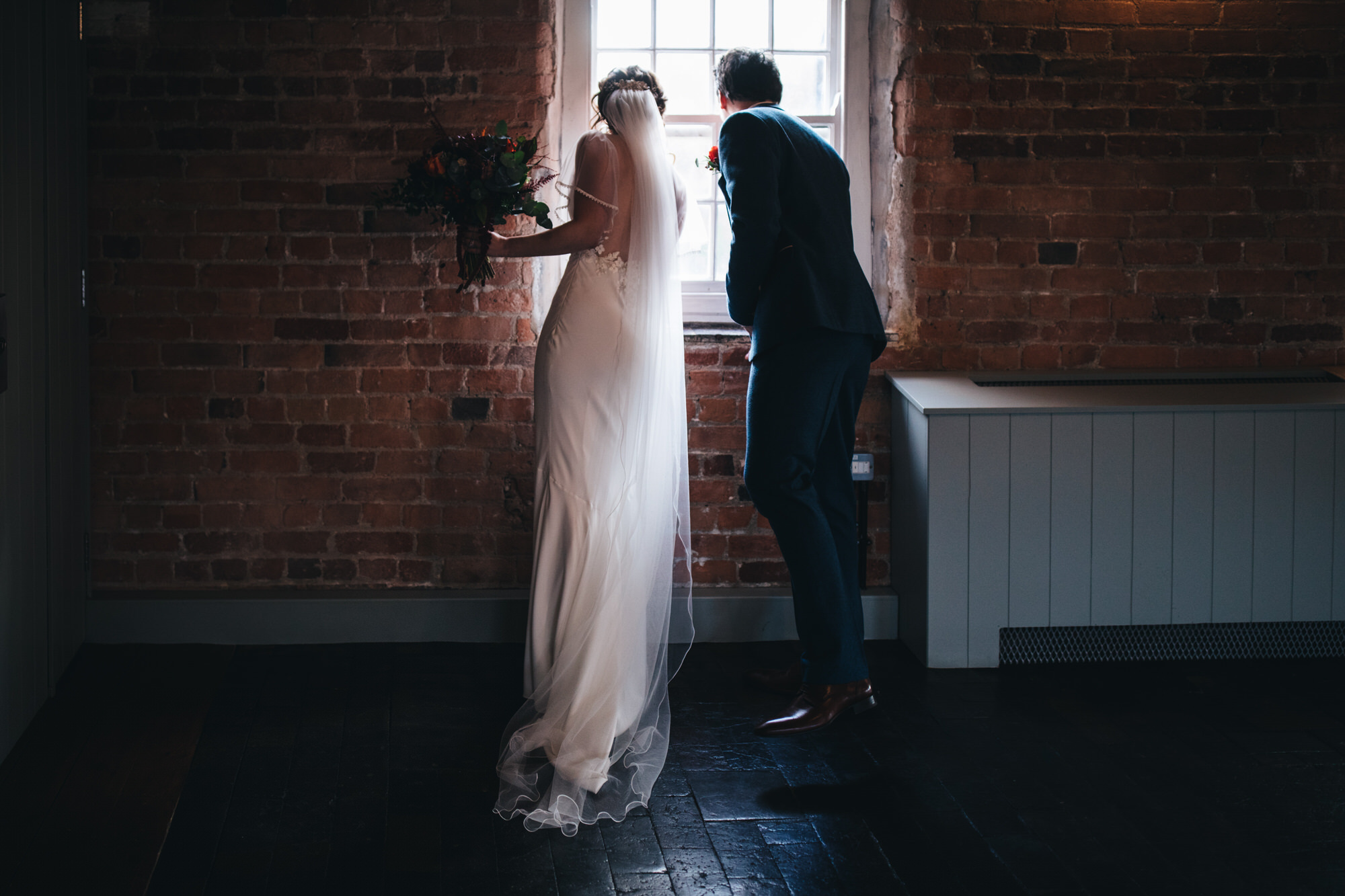 couple peer out of window