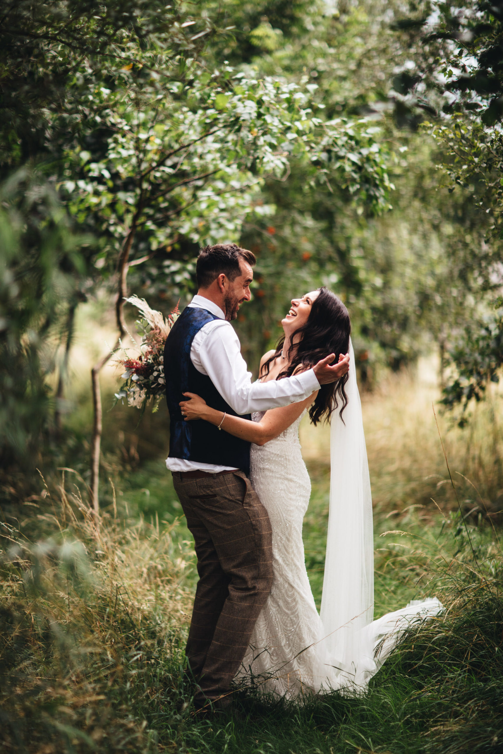 couple laugh together in woods