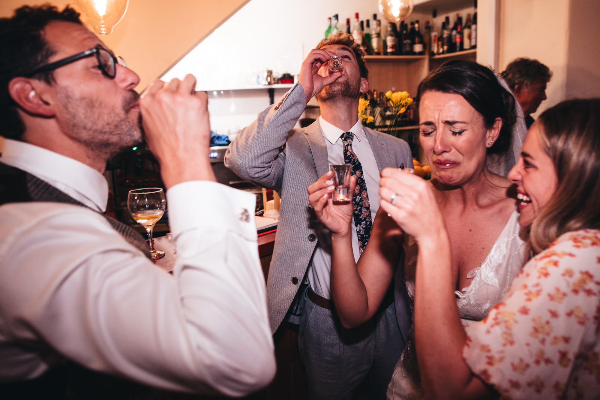 bride pulls funny face after tasting a shot