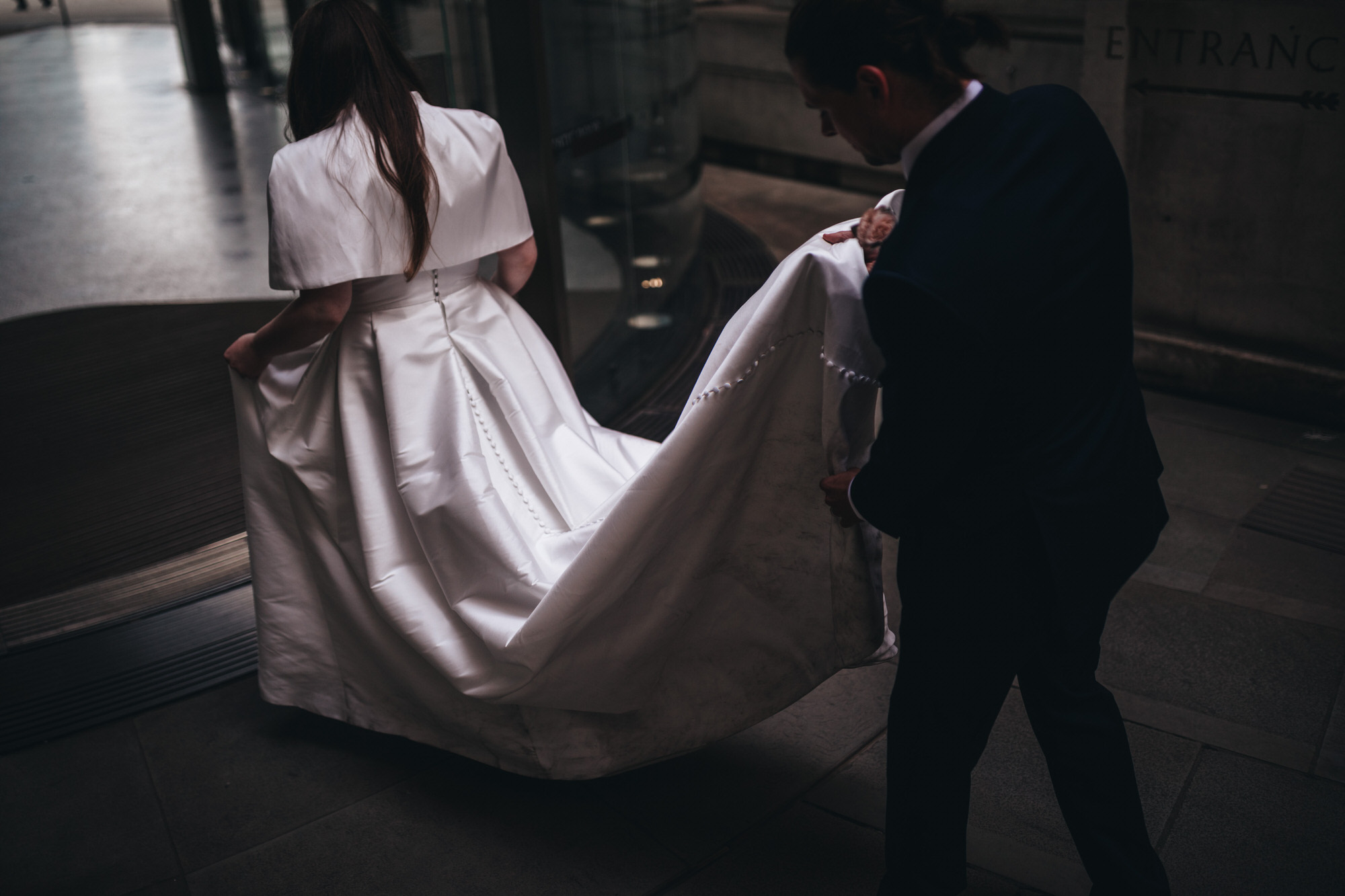 groom lifts dress off the floor