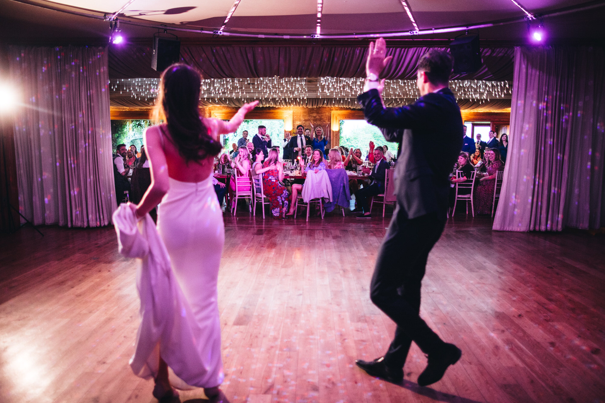curtains pull back to reveal couple having their first dance