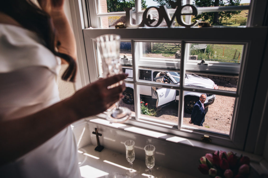 dad looks up at bride from outside