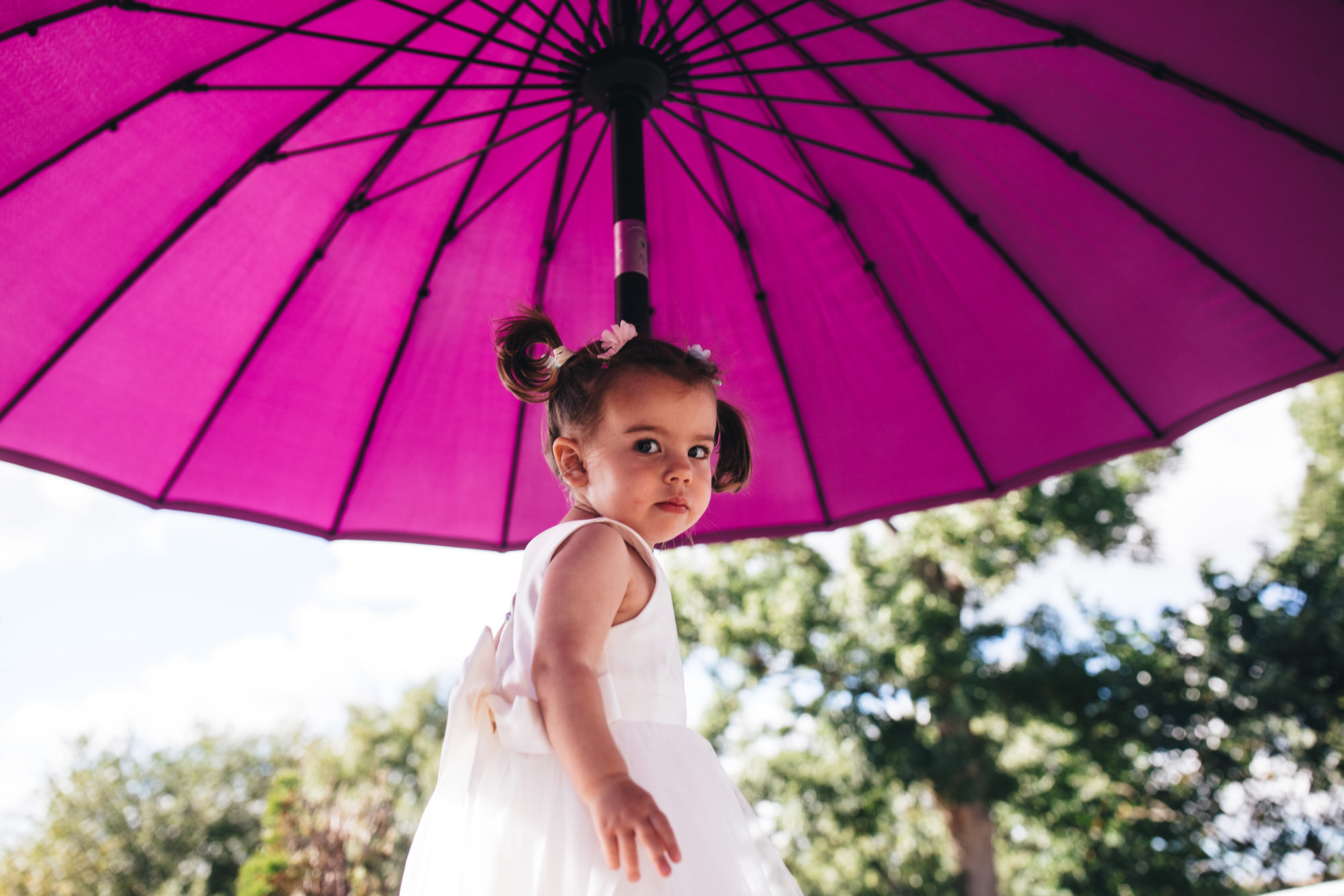 little girl under big purple umbrella