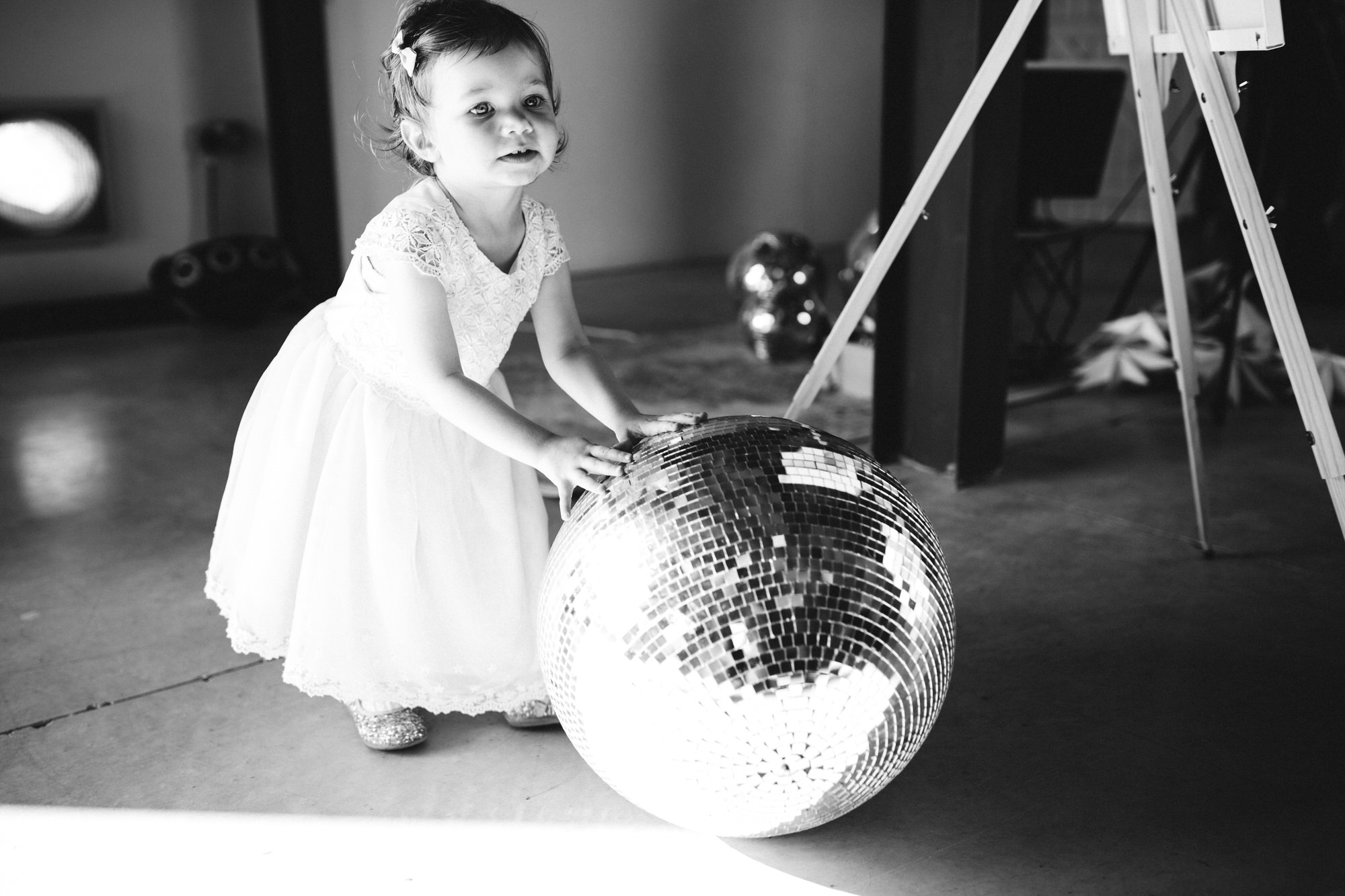 child rolls mirrorball across floor