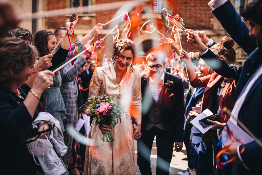 couple walk through ribbons on sticks