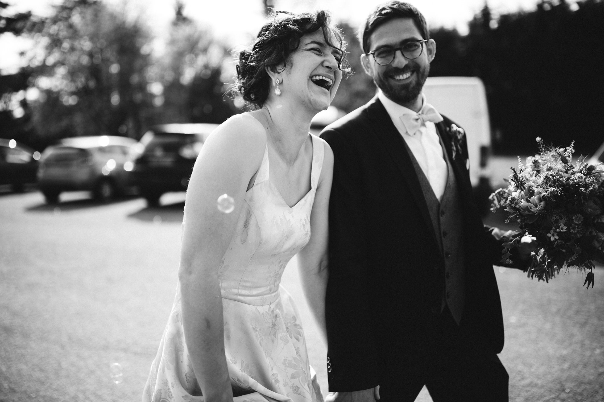 bride laughs while walking with groom