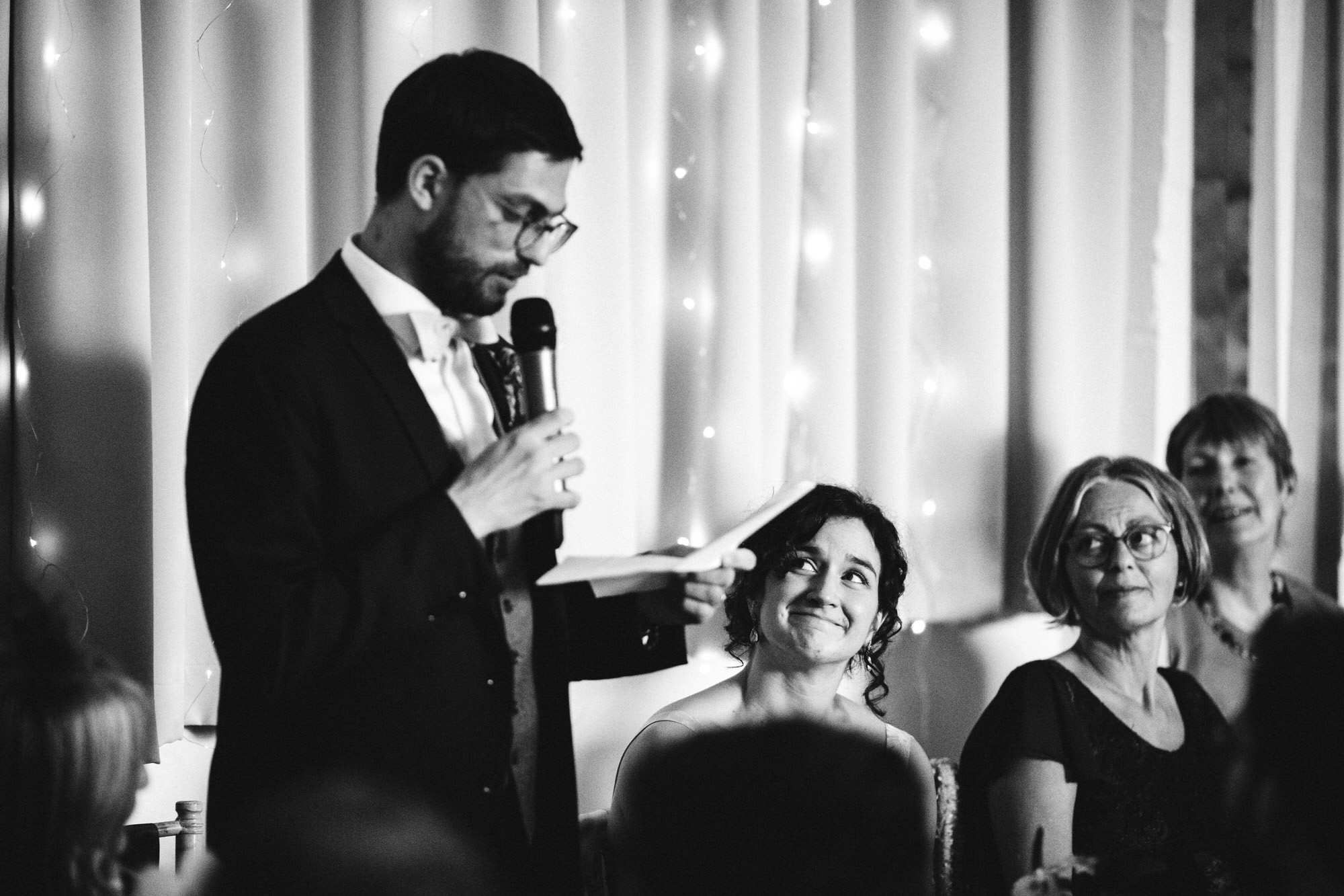 bride watches grooms speech