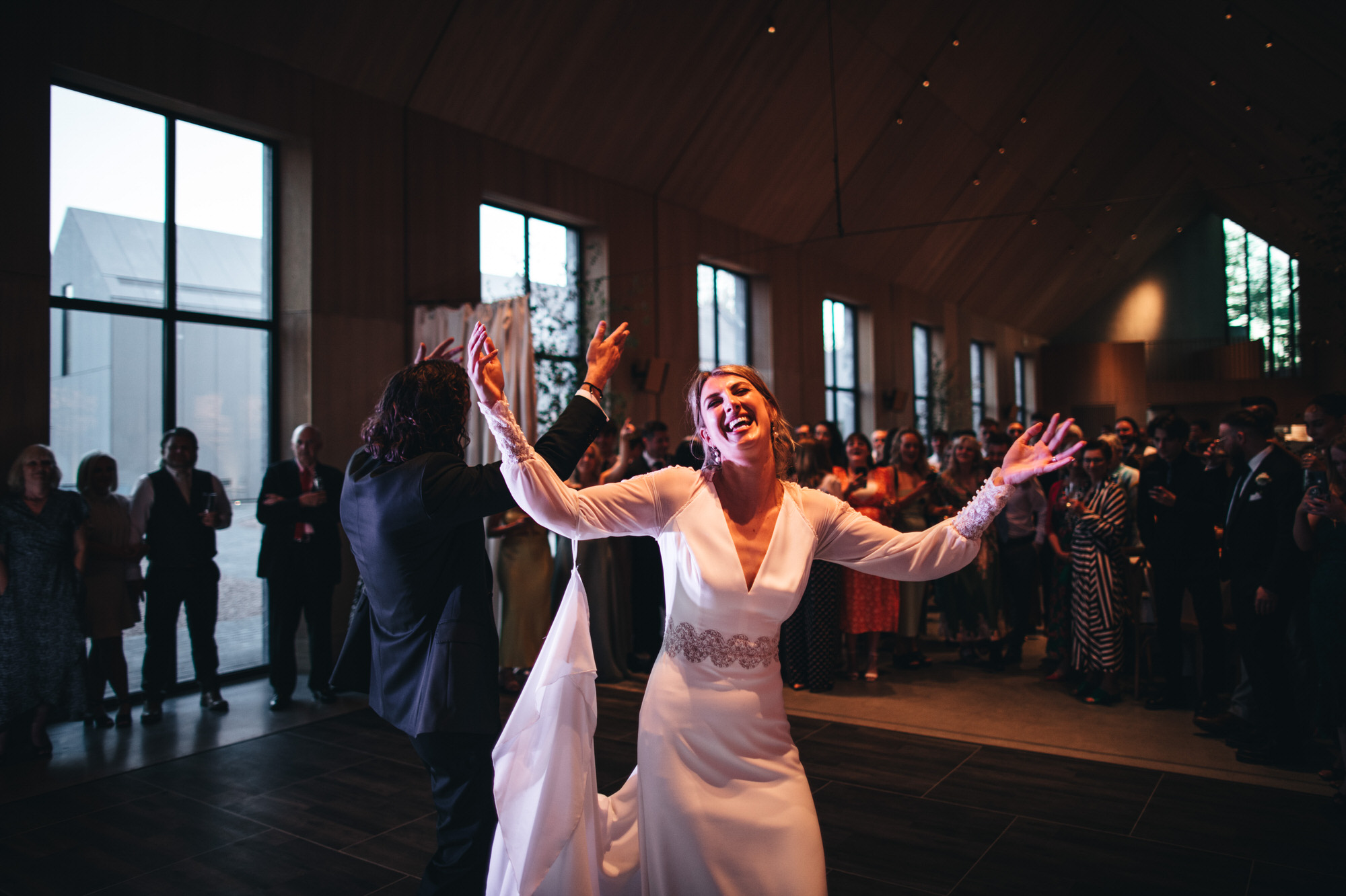 couple raise their arms on dancefloor
