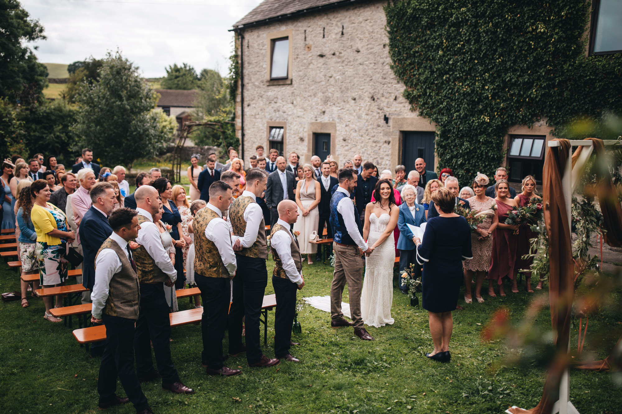 wide view of wedding ceremony outdoors at peak district wedding barn