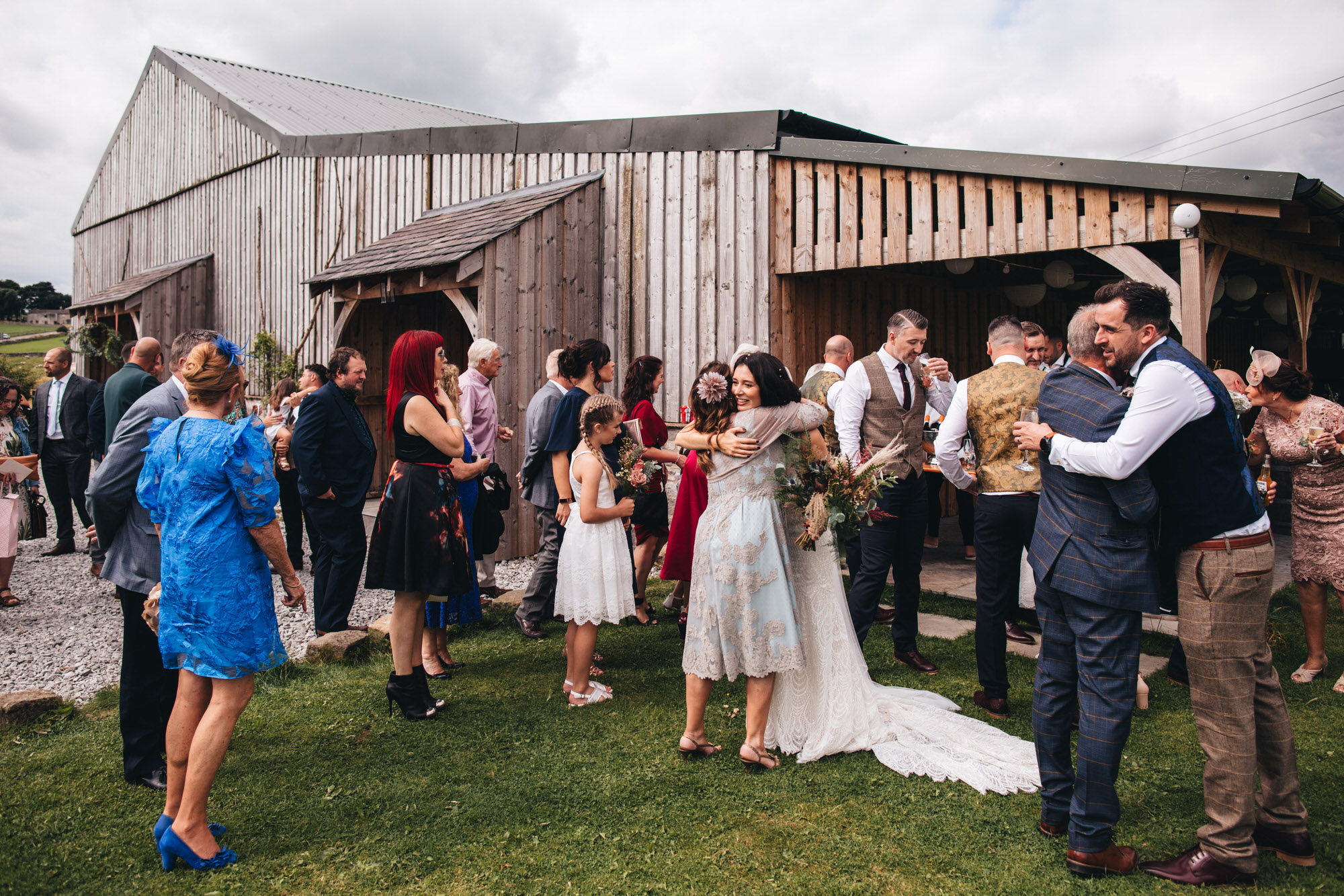 guests congratulating couple outside wedding barn