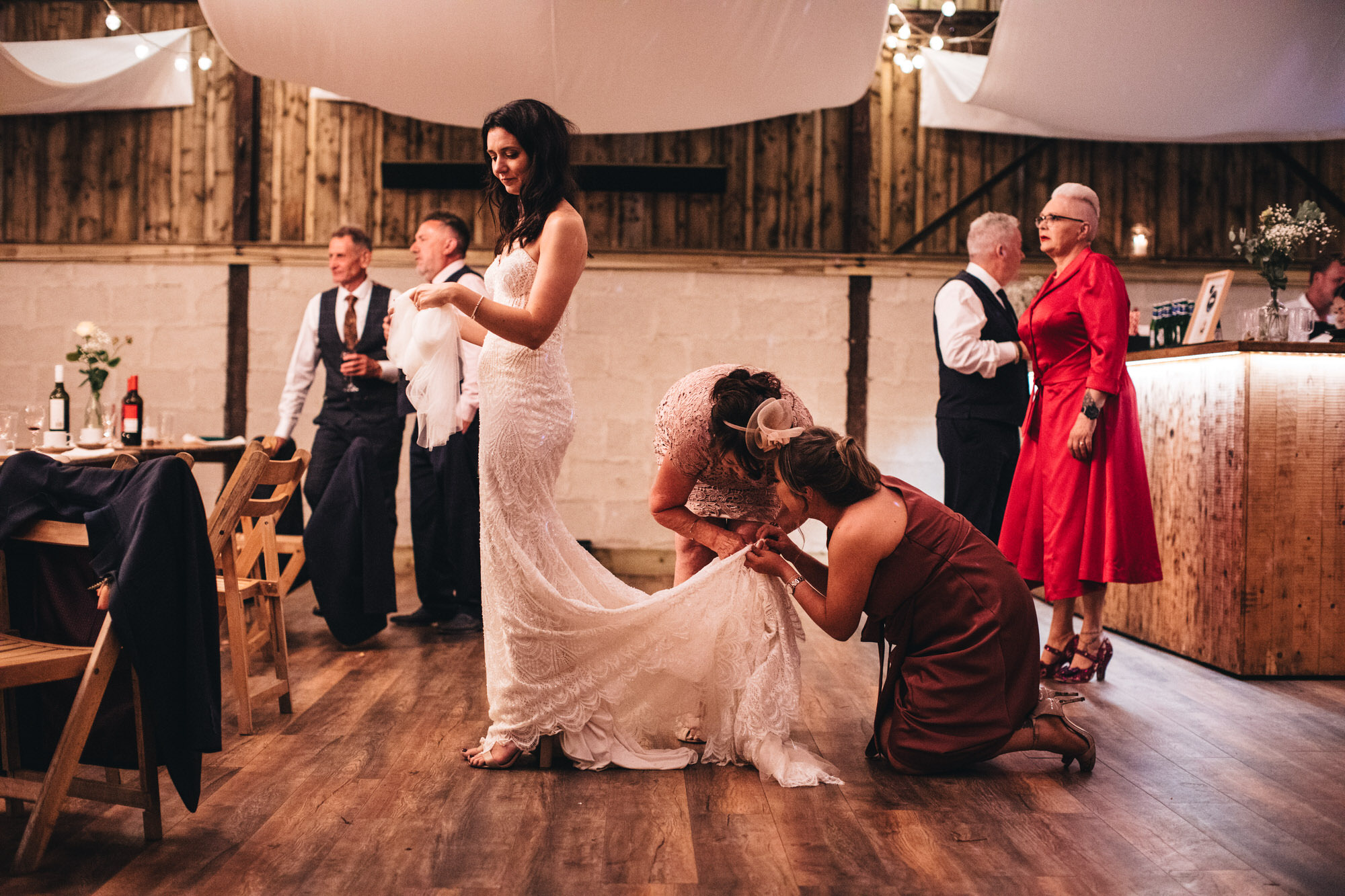 two women on floor fixing wedding dress