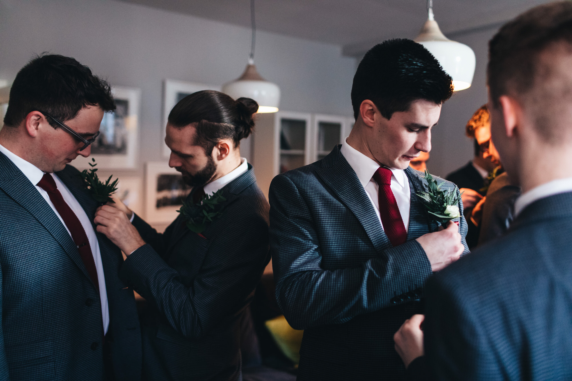 men putting on button holes before wedding