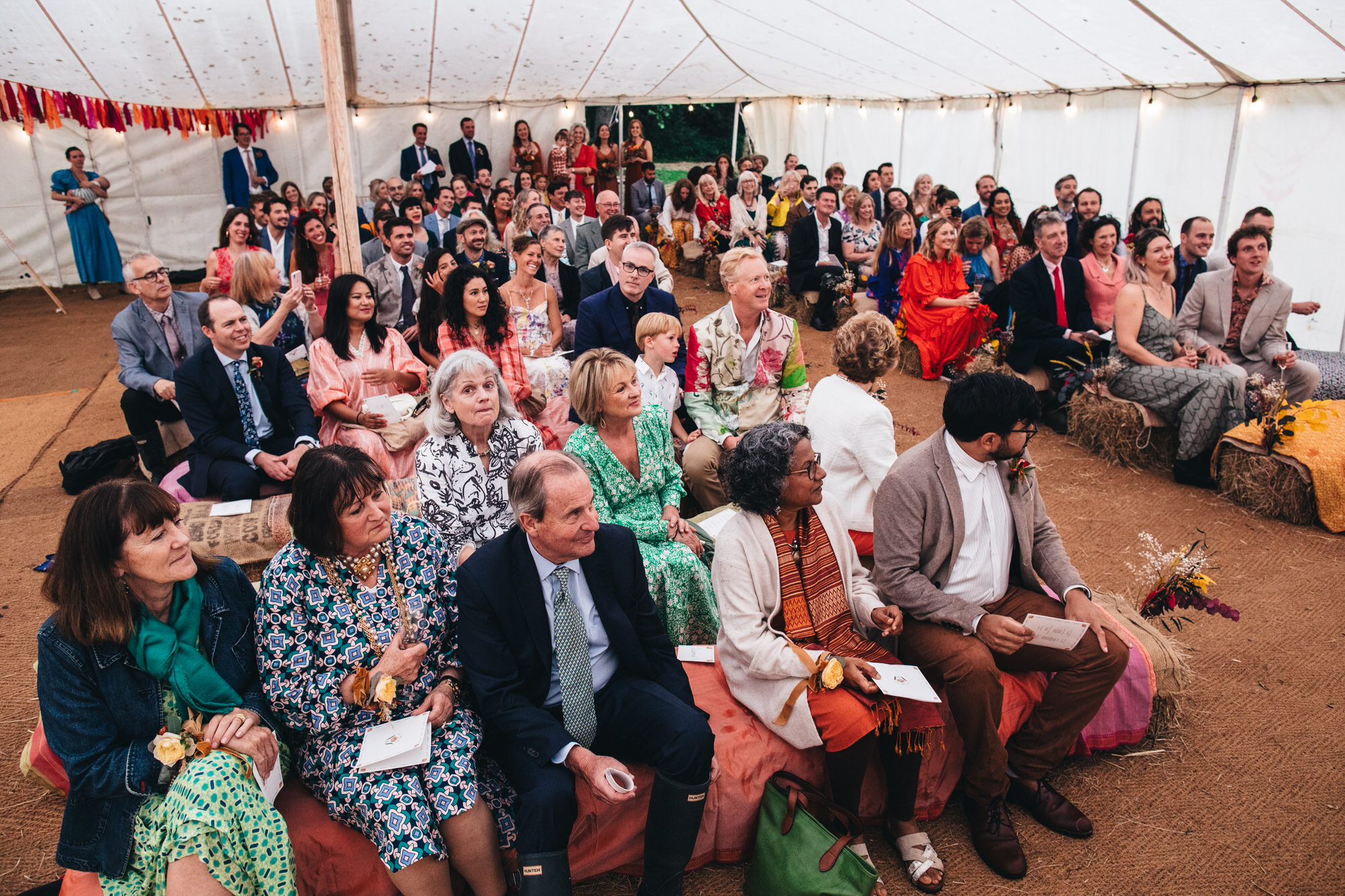 guests sitting inside marquee tent waiting for ceremony