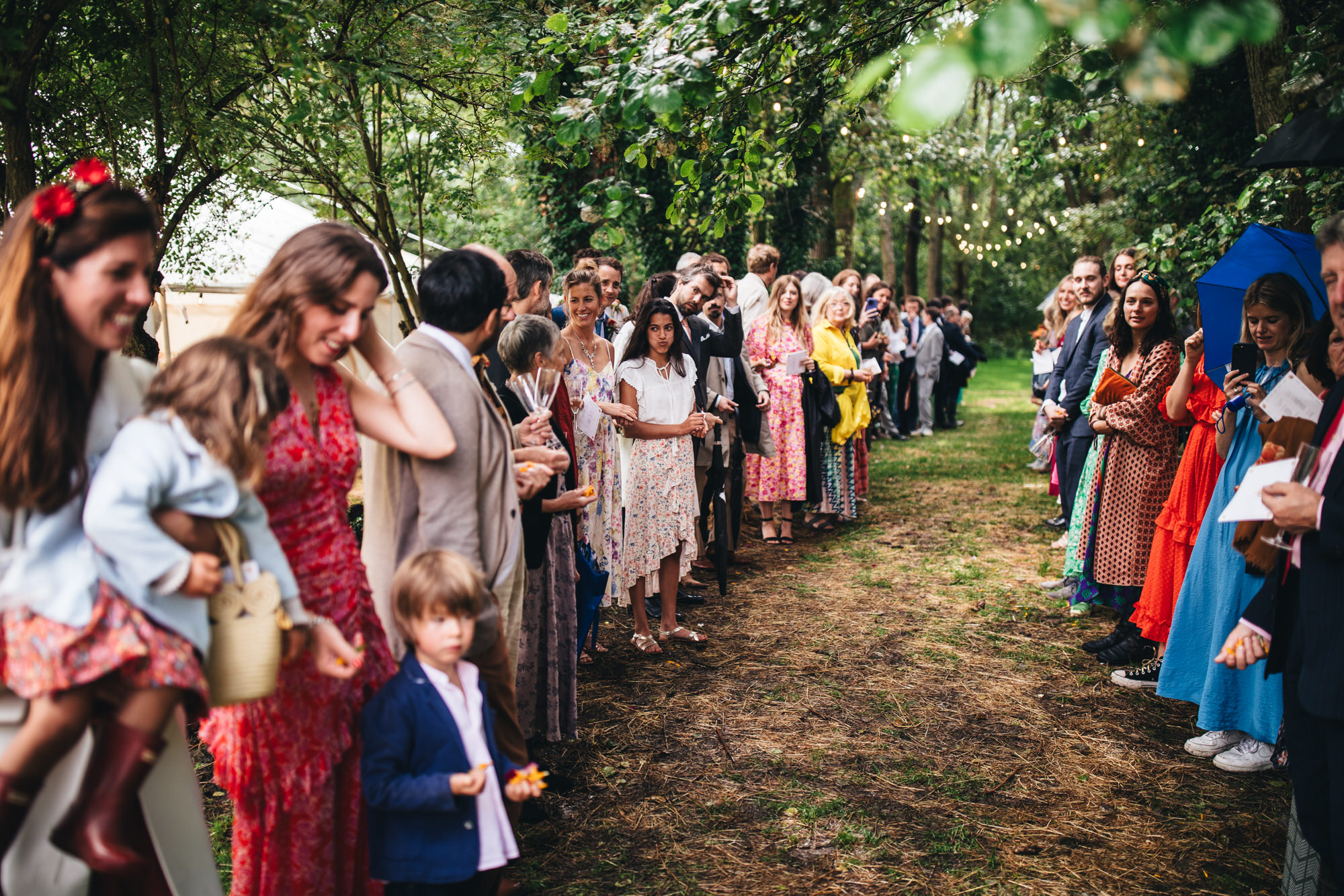 guests waiting in a line through trees
