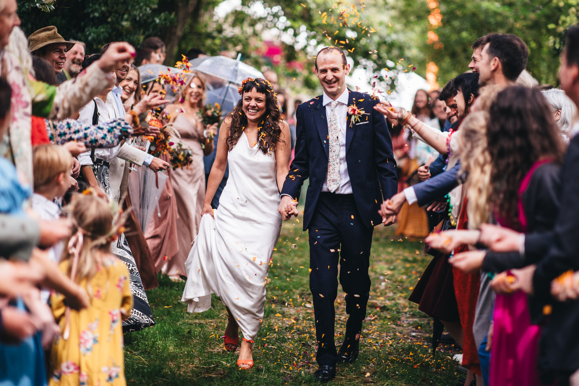 guests throw confetti at the bride and groom