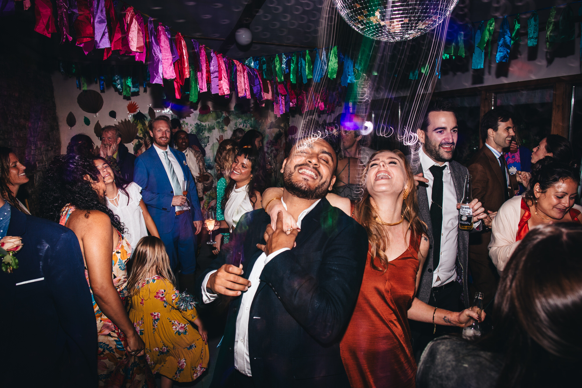 guests singing and dancing on dancefloor with disco ball