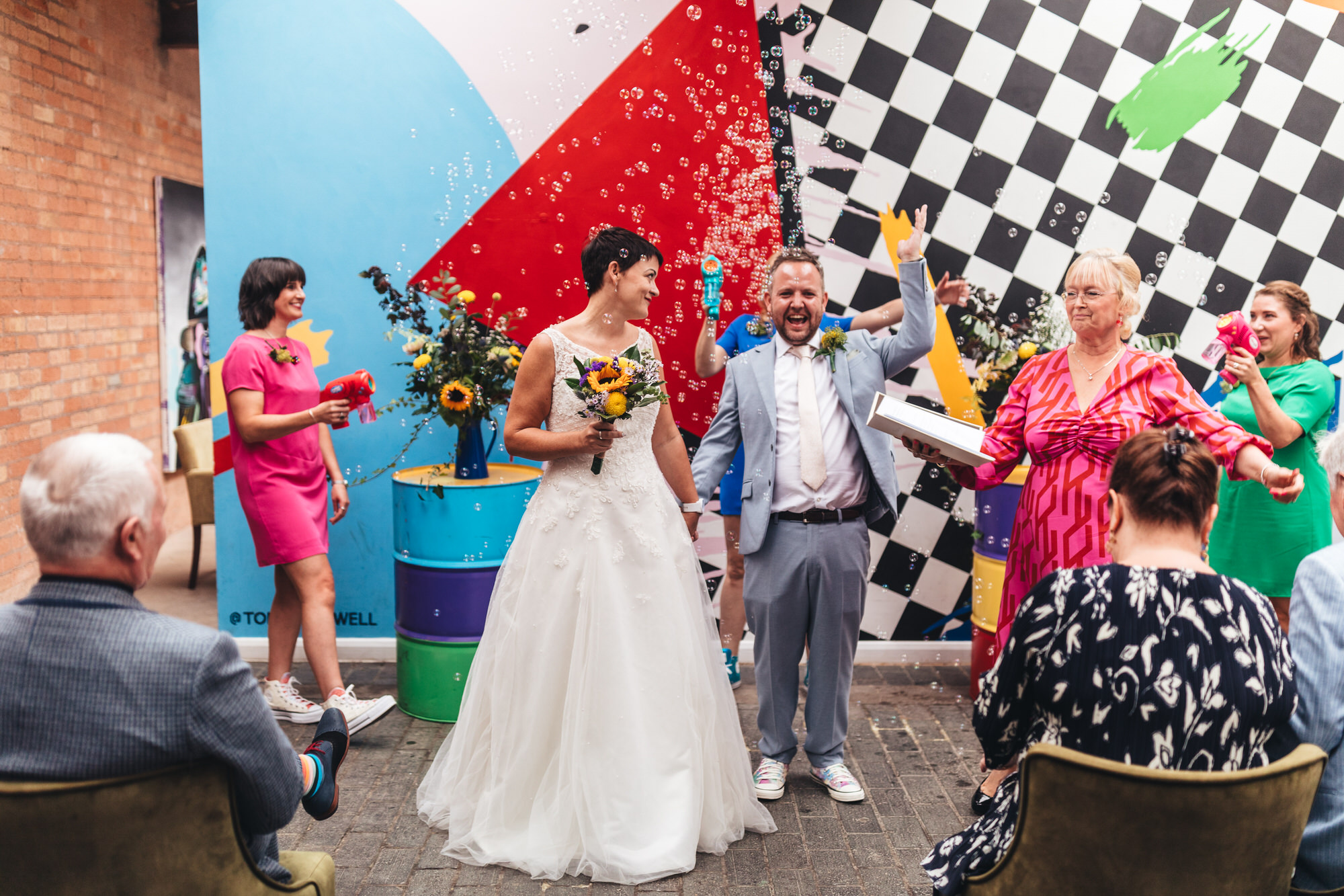 bride and groom celebrate walking through bubbles