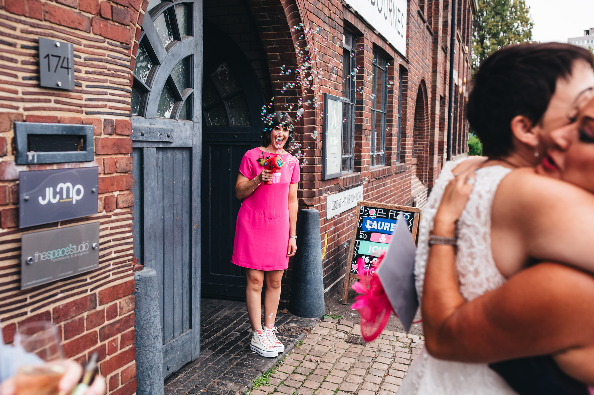 bridesmaid in pink shift dress with bubble gun