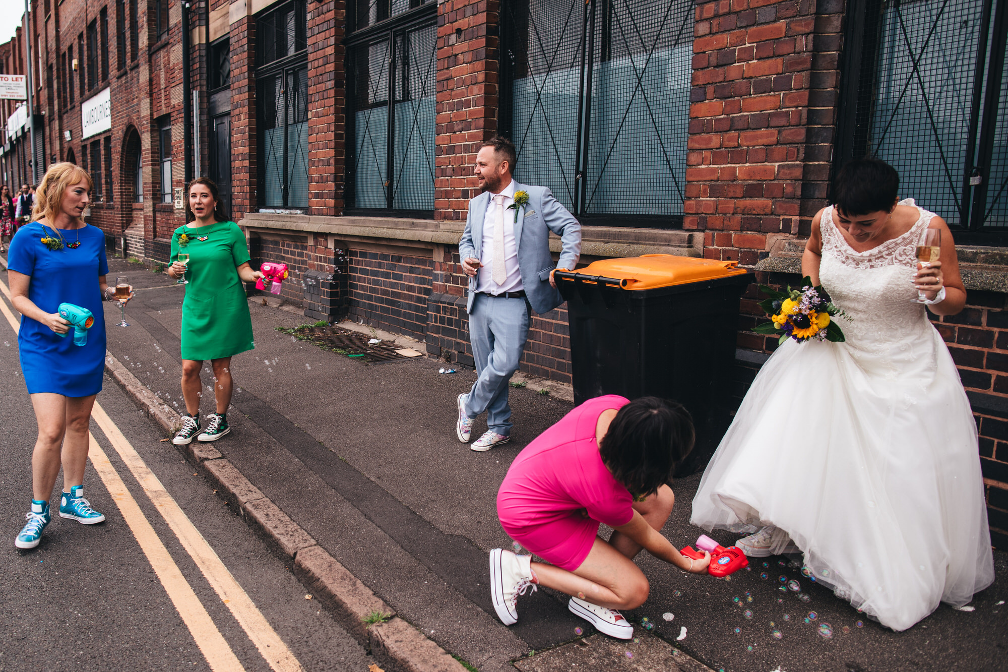 bride and groom with bridesmaids next to bin