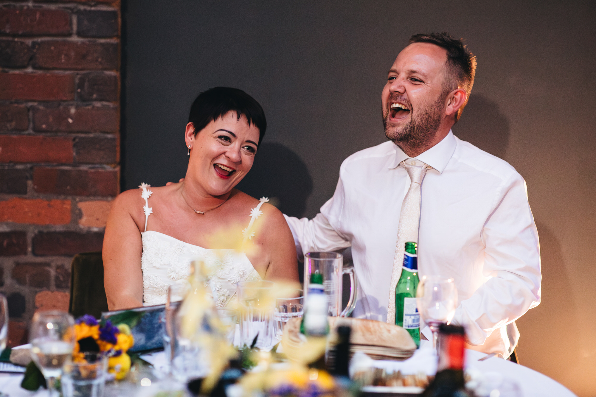 bride and groom laughing at table