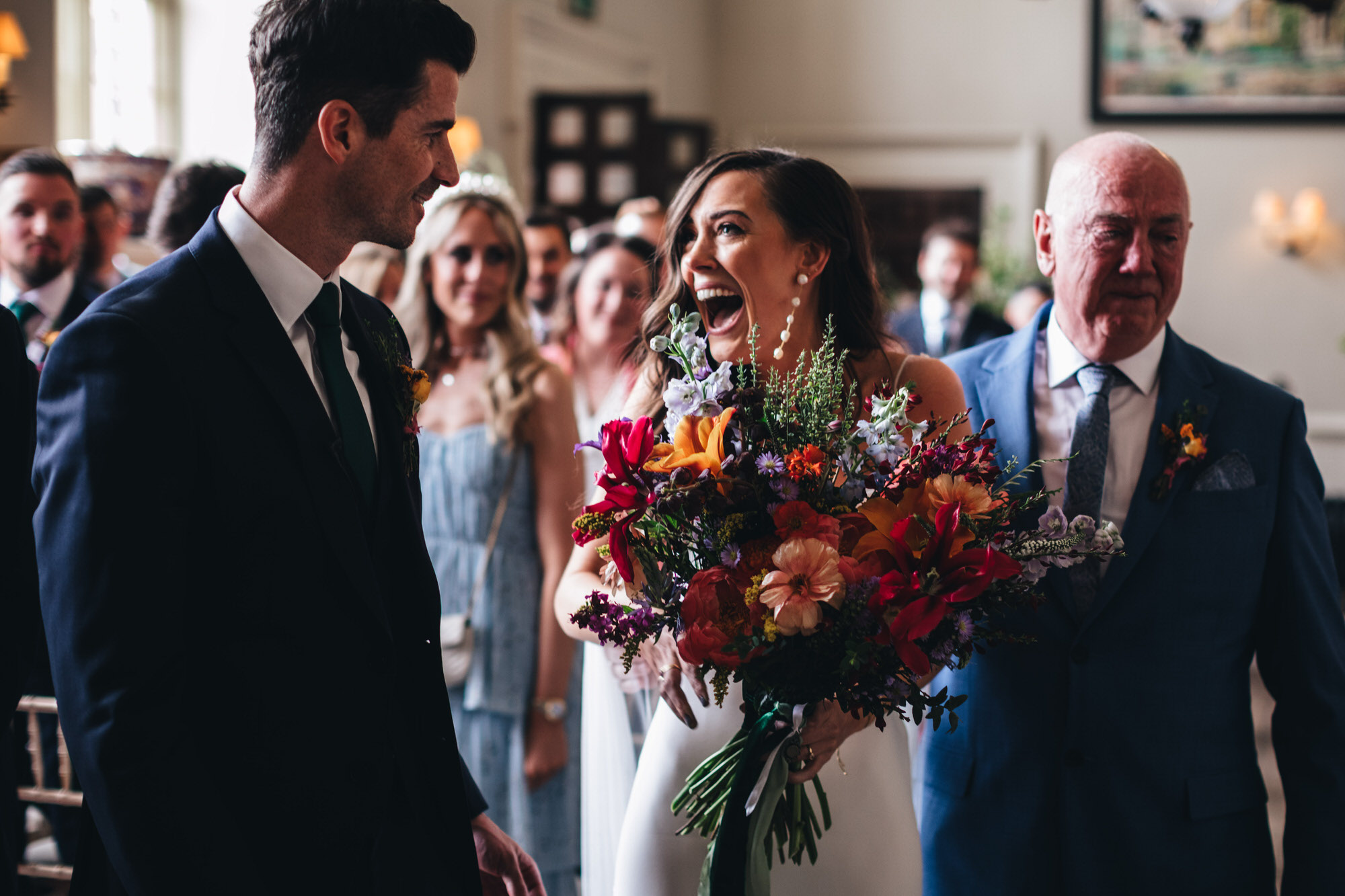 bride with big smile for groom at ceremony, holding Wren and May wedding bouquet flowers