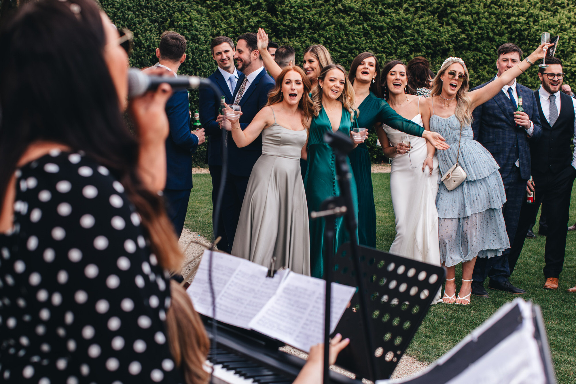 guests and bride sing along to wedding music performers outside