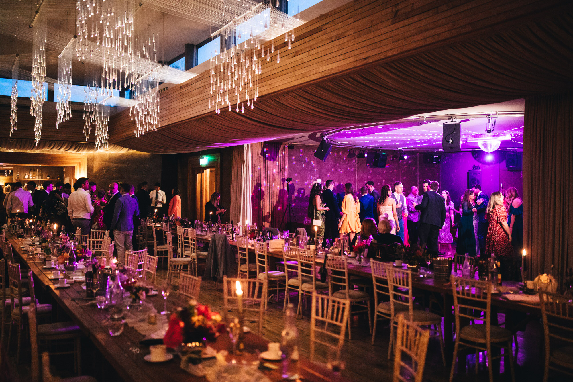 wide shot interiors wedding at The Gillyflower, Elmore Court, guests under evening lights, evening wedding photography
