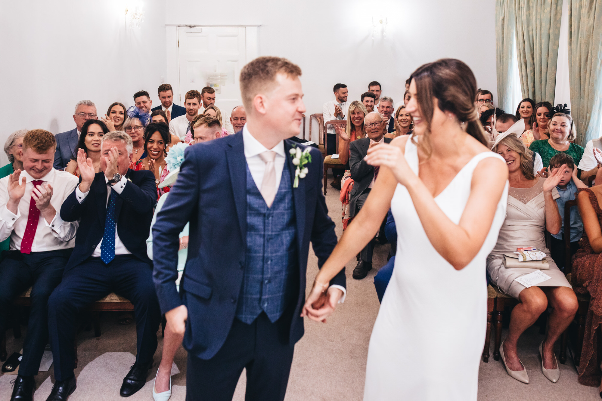 guests applaud, clapping bride and groom at ceremony