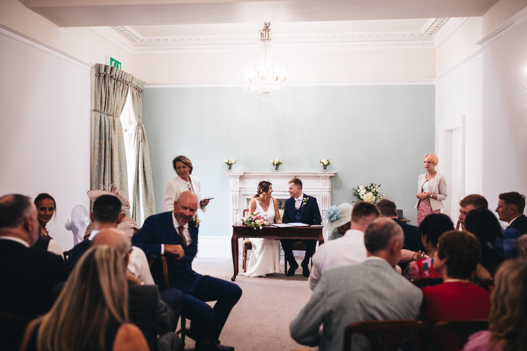 bride and groom talking, smiling as guests chat at ceremony