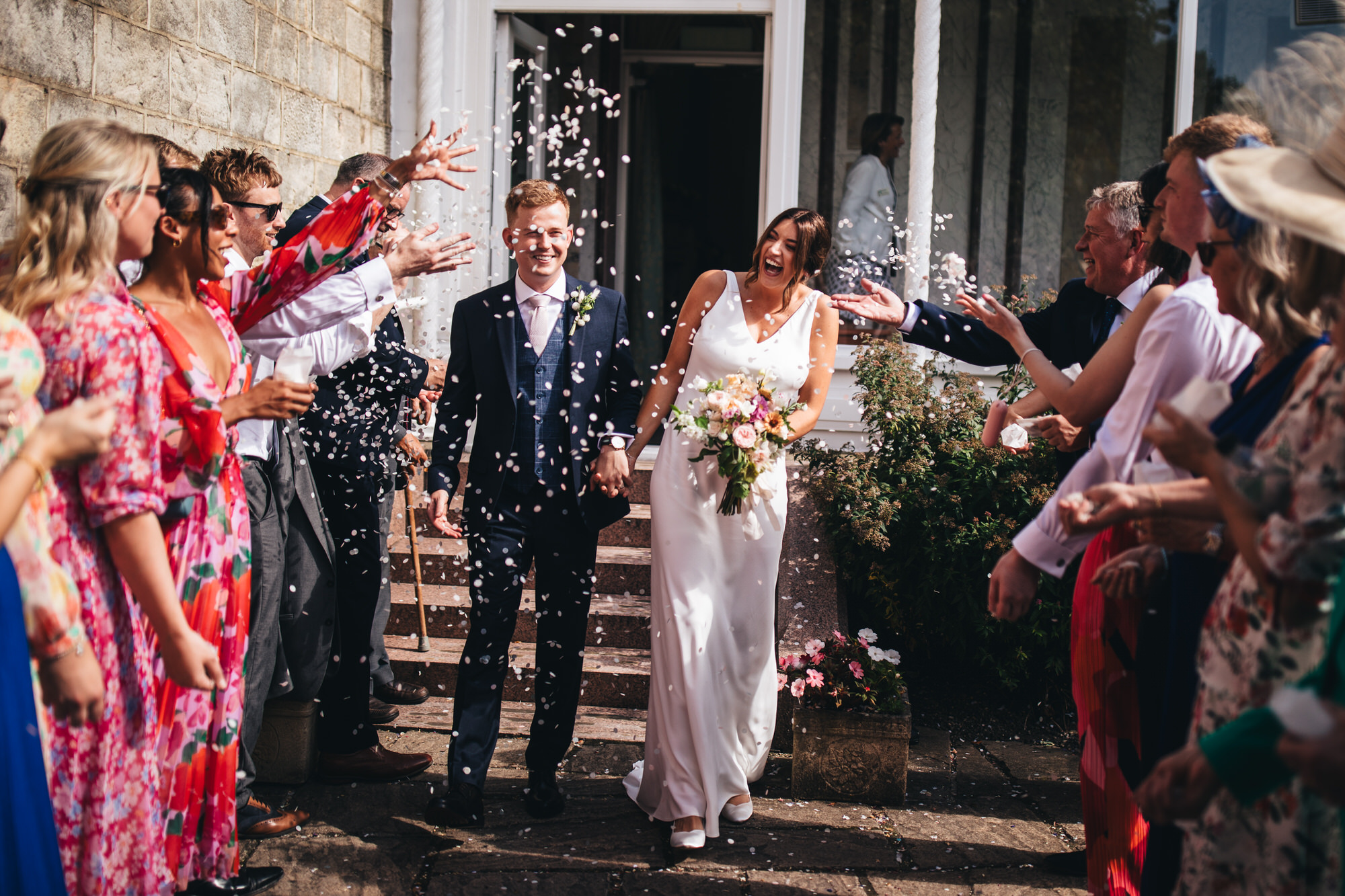 guests throw confetti at bride and groom