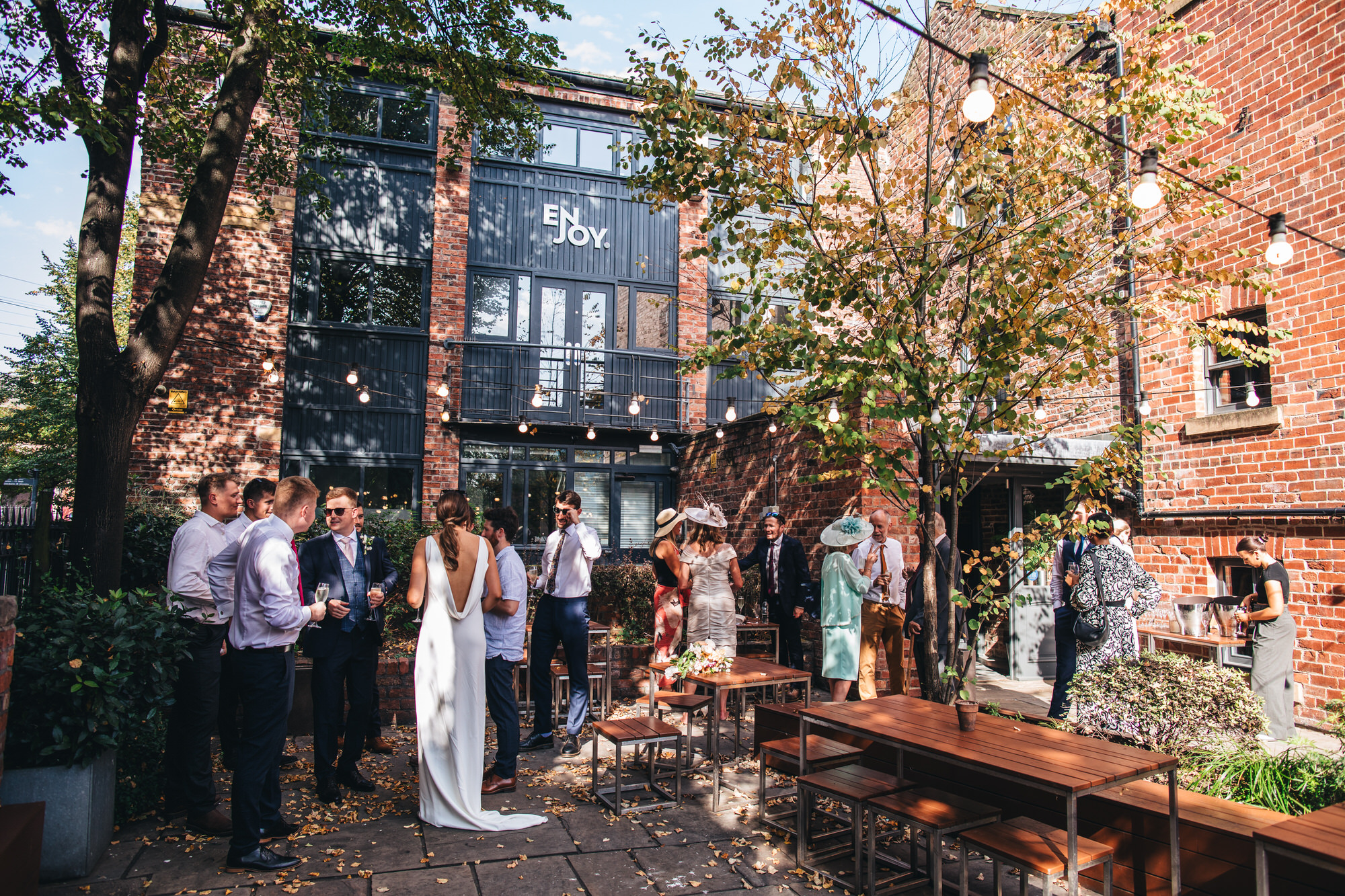 exteriors bride and groom and guests at shears yard in sunshine