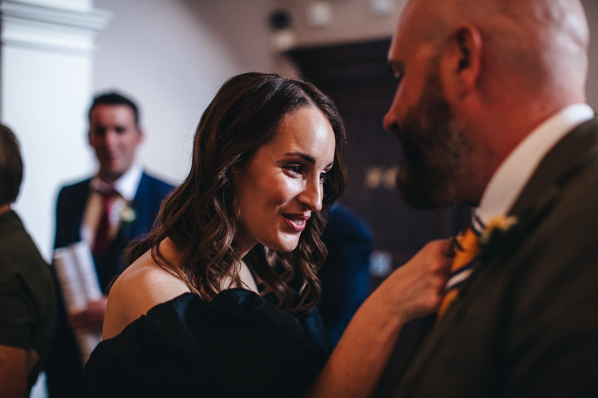 guest looks closely at groom's suit lapel