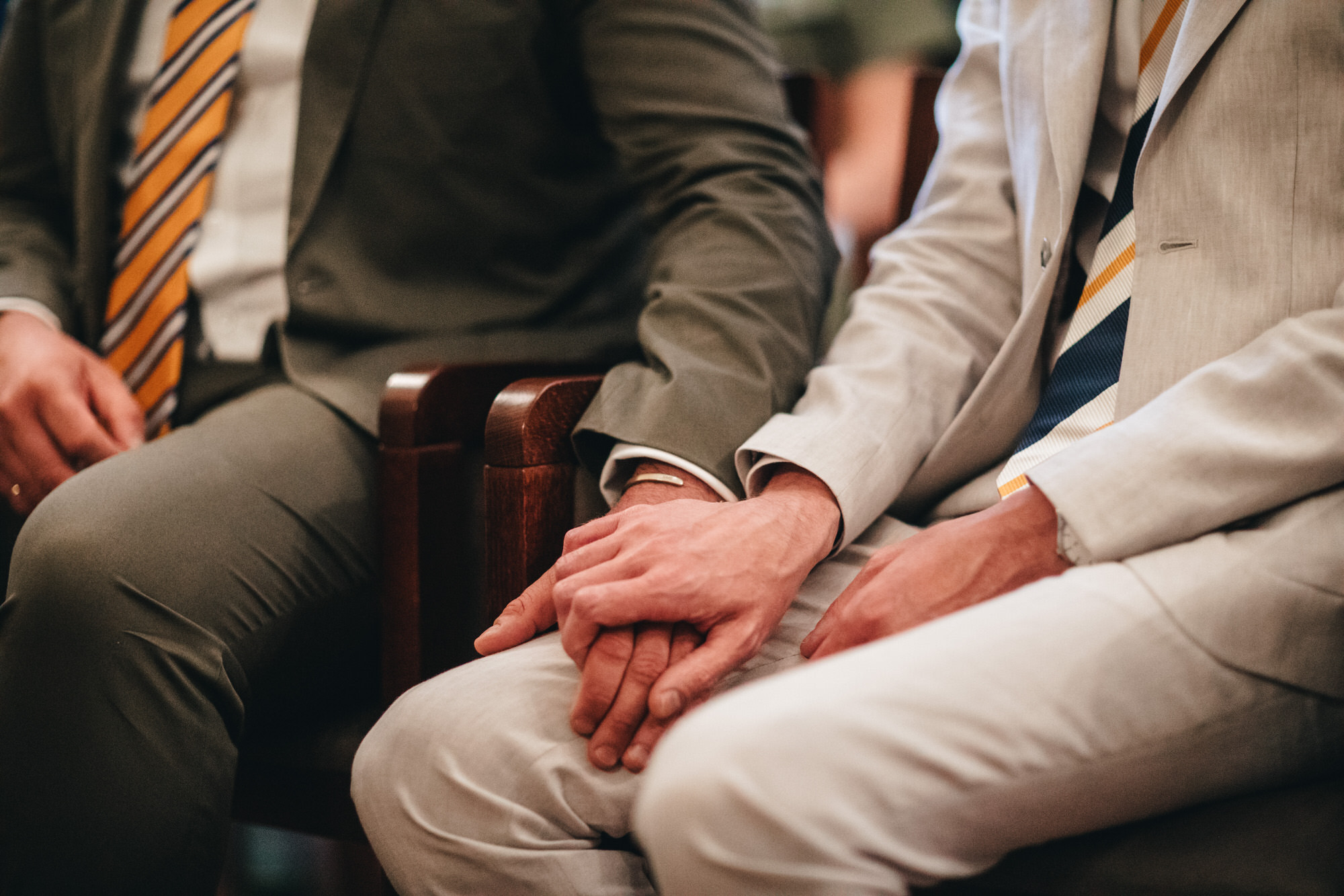 close grooms holding hands, gay wedding