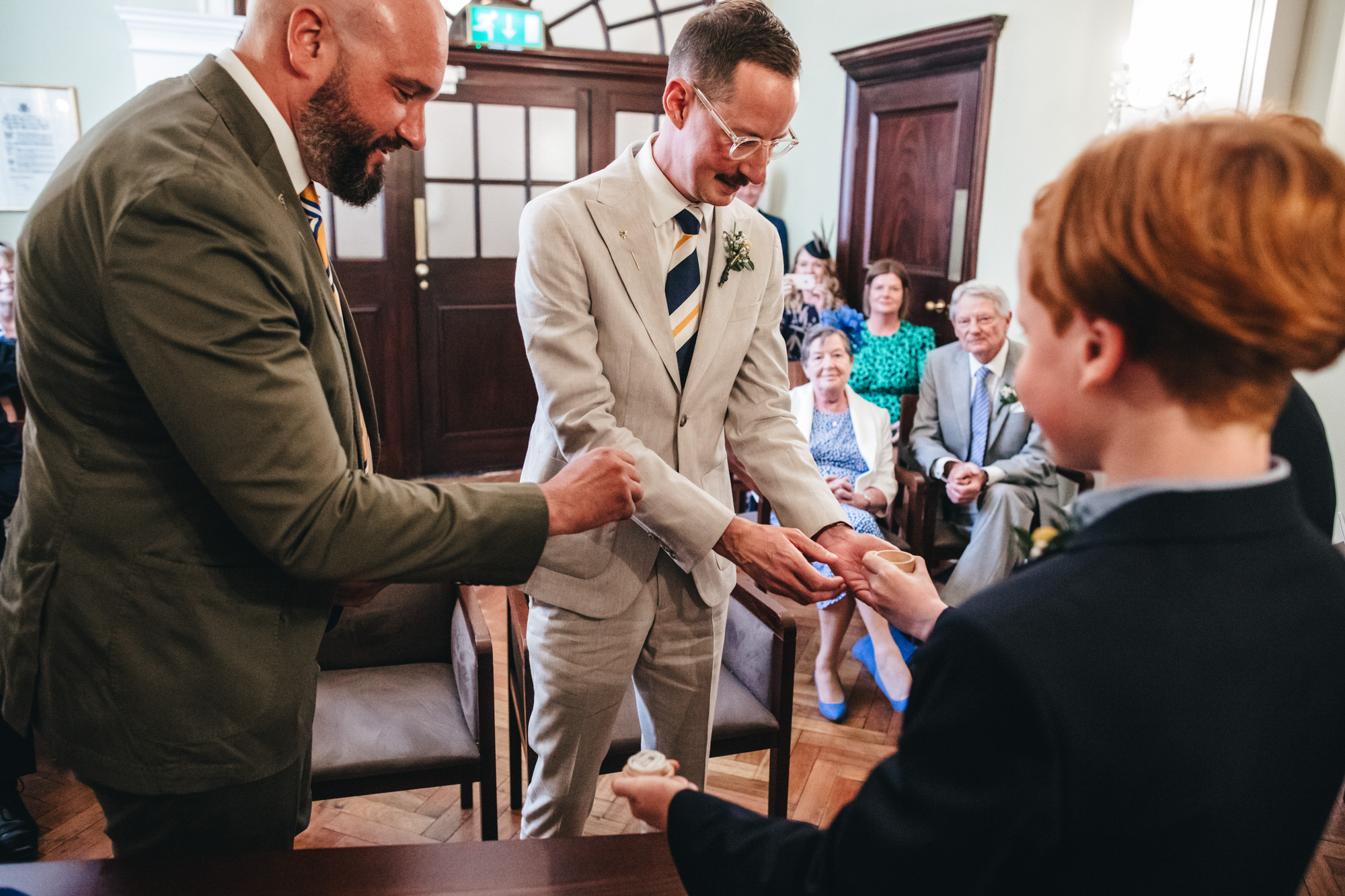 grooms taking wedding rings at Chelsea Old Town Hall wedding
