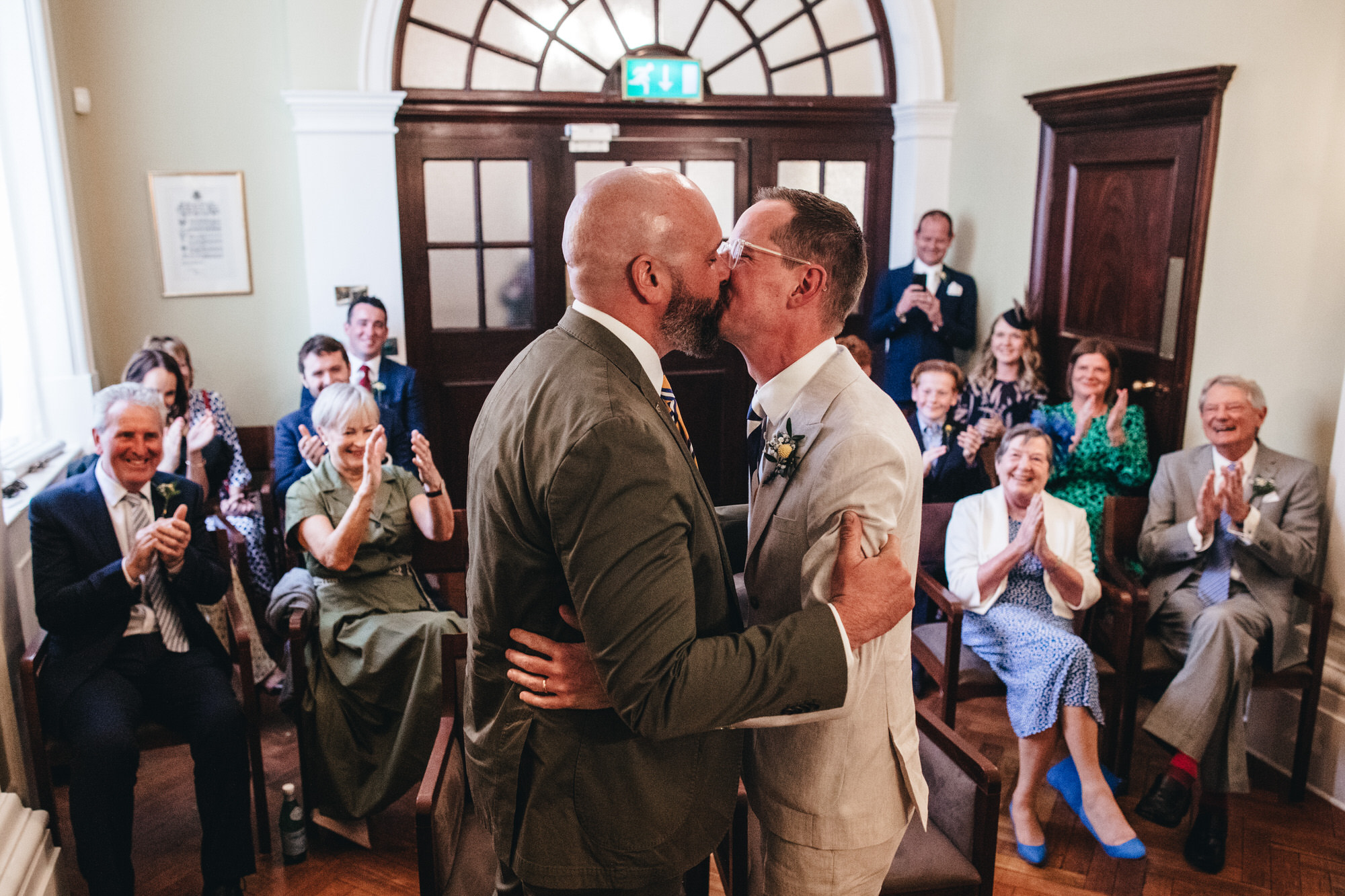 grooms kiss at Chelsea Old Town wedding with guests applauding at ceremony