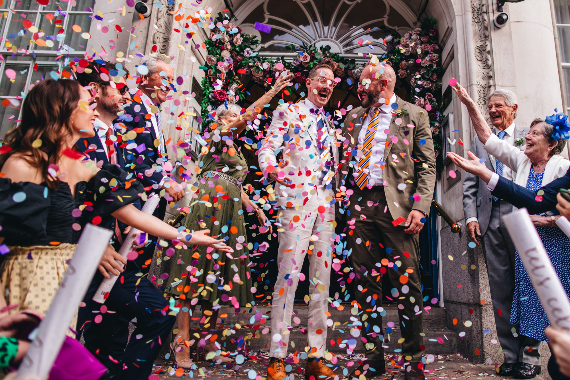 confetti cannon, grooms laughing together with guests, London wedding