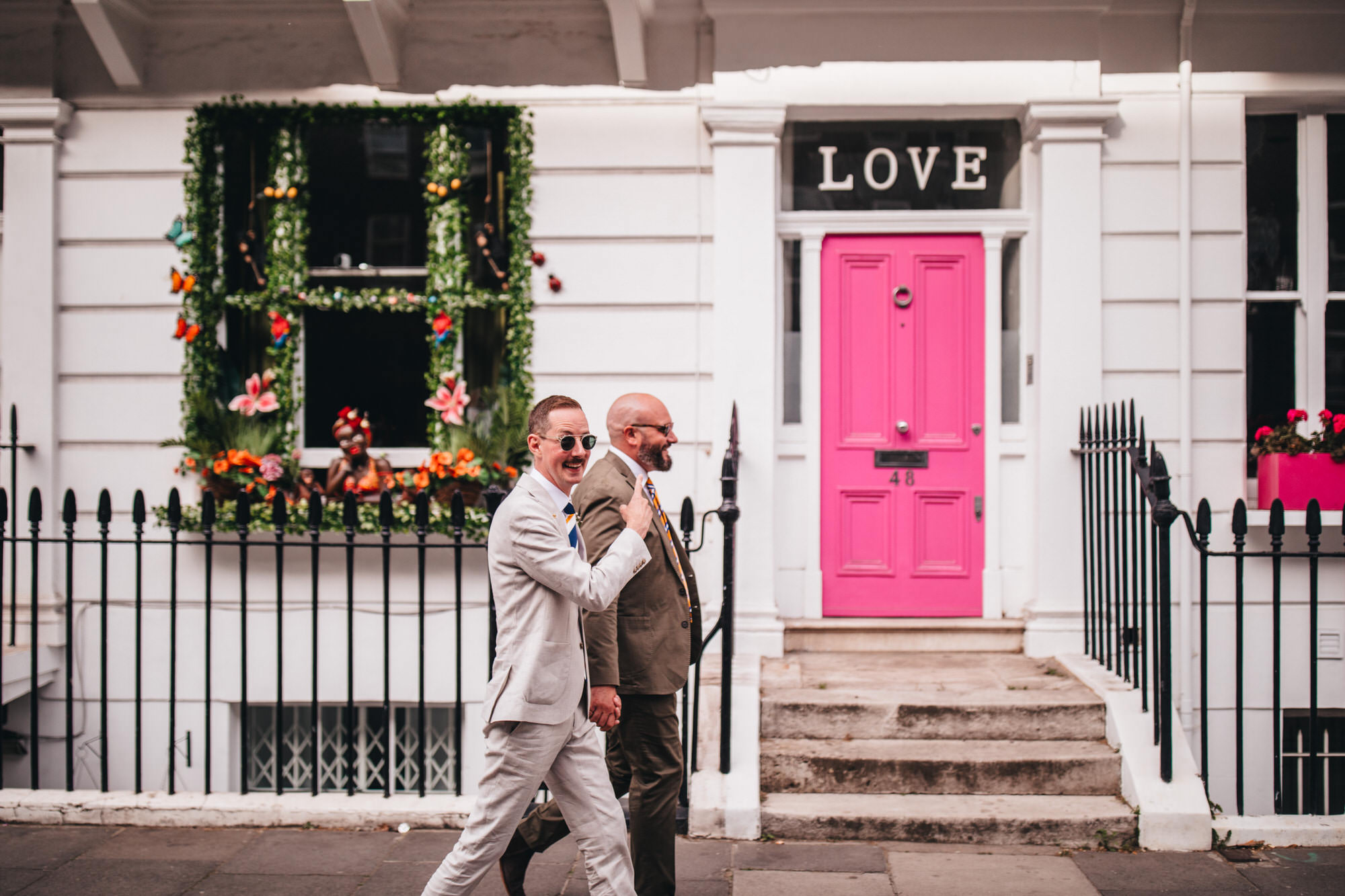 LGBTQ+ wedding, grooms walking through Chelsea together, holding hands