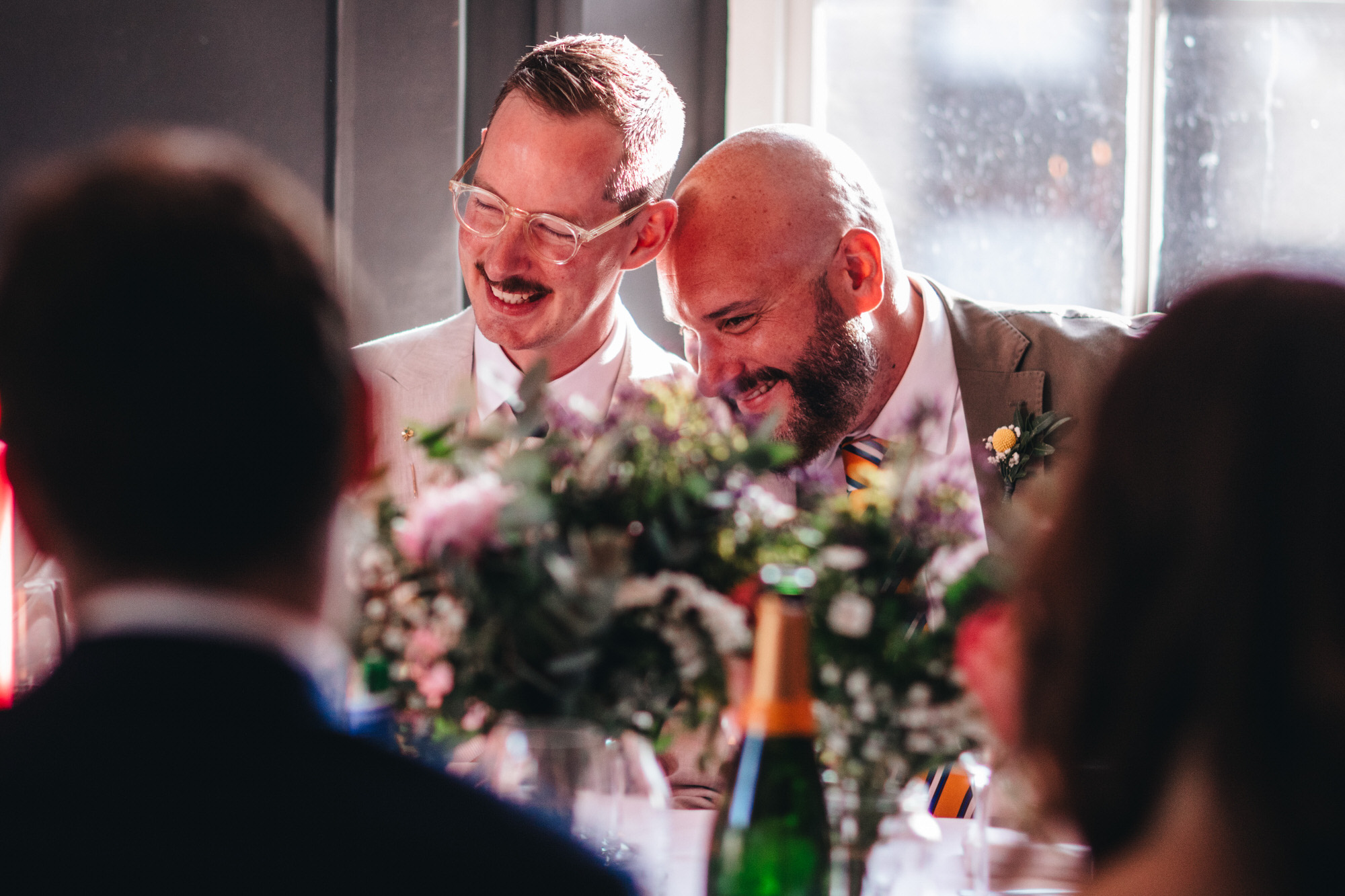 grooms laughing together, intimate moment at wedding breakfast, LGBTQ+ wedding, The Phene pub